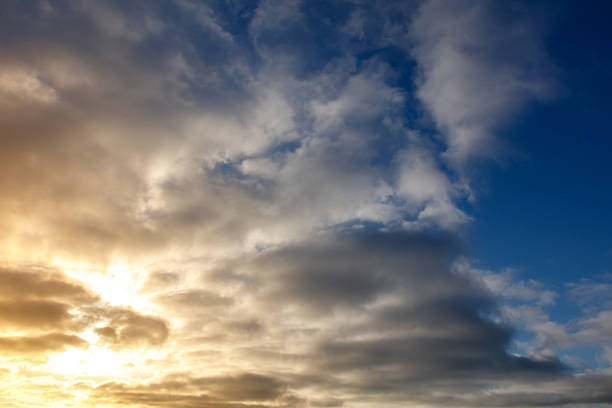 The sky is blue with a few clouds. The sun is shining through the clouds. The sky is very clear and bright
