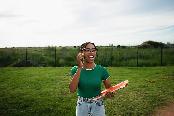 istock Cheerful young student laughing outdoors holding folders 2214245507