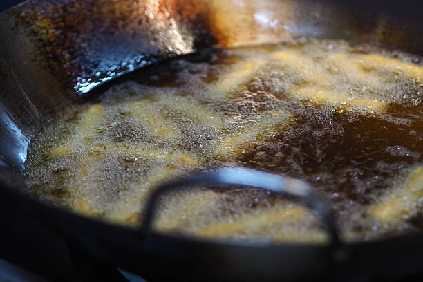 istock Churros are being fried in a pan, good for article or recipe 2214245705