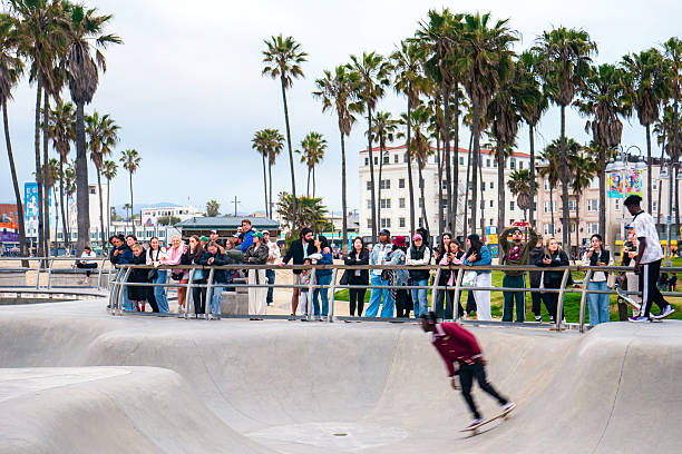 Skateboarders at the Venice Beach Skatepark in Venice, California. Crowds of spectators watch as skate boarders perform tricks in the skate park near Los Angeles.