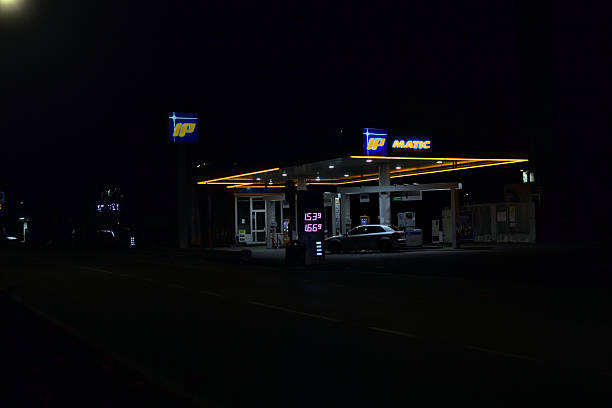 Boulder, Colorado, USA - October 9, 2025: Car pulling up to a Shell gas station pump under the illuminated canopy at night