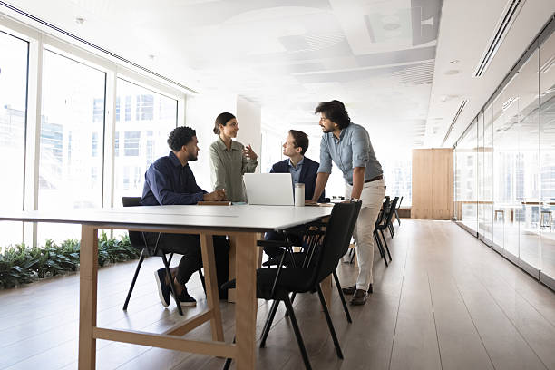 istock Multiethnic coworkers talking at meeting table with laptop 2214250231
