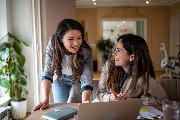istock Two businesswomen collaborating on a project, sharing a laugh at the office 2214256027