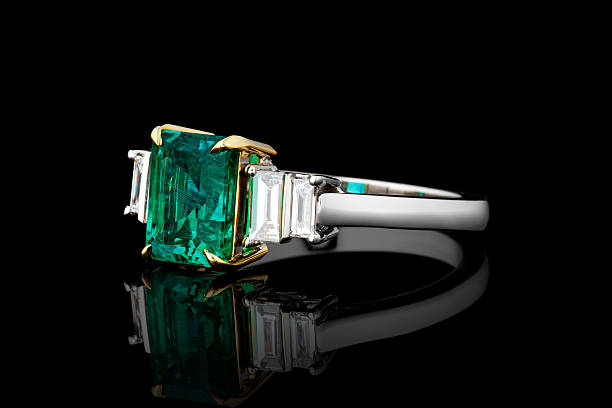 istock silver or gold ring with emerald stone and diamonds on black background 2214256284