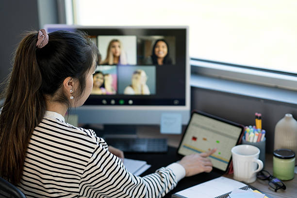 istock Woman Attending Virtual Meeting in Home Office Setting with Modern Equipment 2214257468