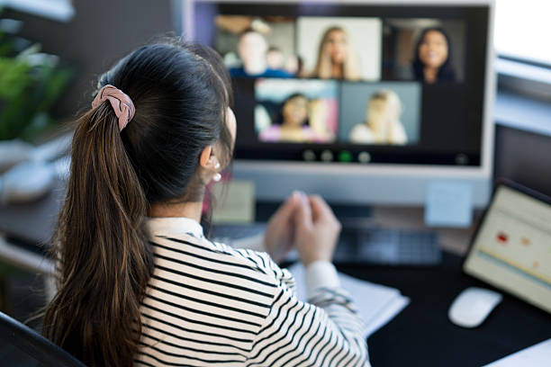 istock Woman Attending Virtual Meeting in Home Office Setting with Modern Equipment 2214257475