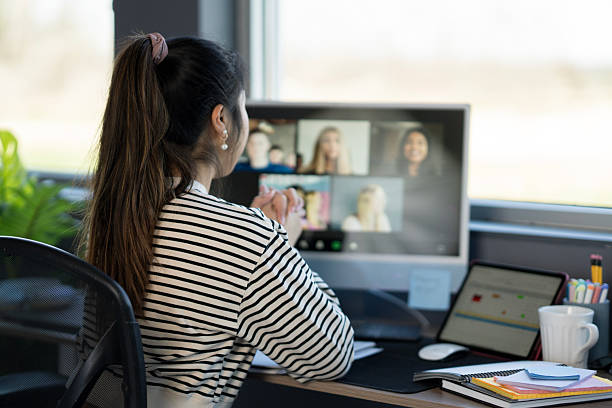 istock Woman Attending Virtual Meeting in Home Office Setting with Modern Equipment 2214257483