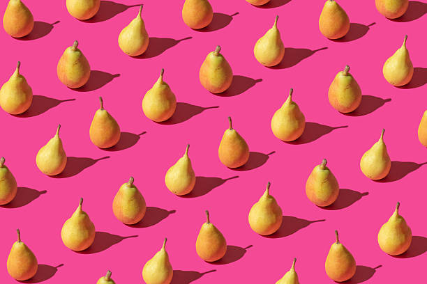 istock Creative pattern made with fresh pears against pastel pink backround.Minimal summer fruit layot. 2214257915