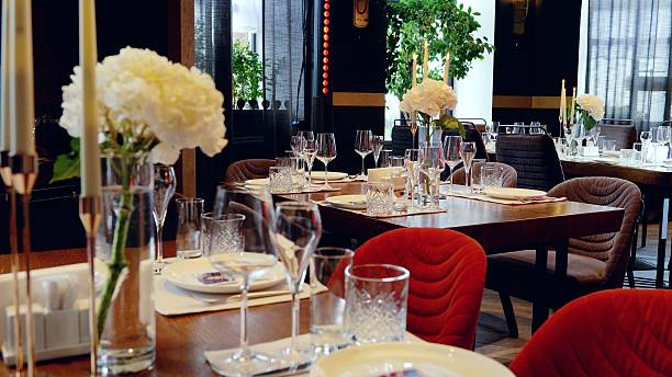 istock Rustic wooden tables featuring fine dinnerware, crystal glassware, delicate floral centerpieces, and softly glowing candles setting elegant dining ambiance 2214262538