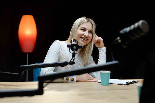 istock Smiling woman recording podcast in home studio 2214264169