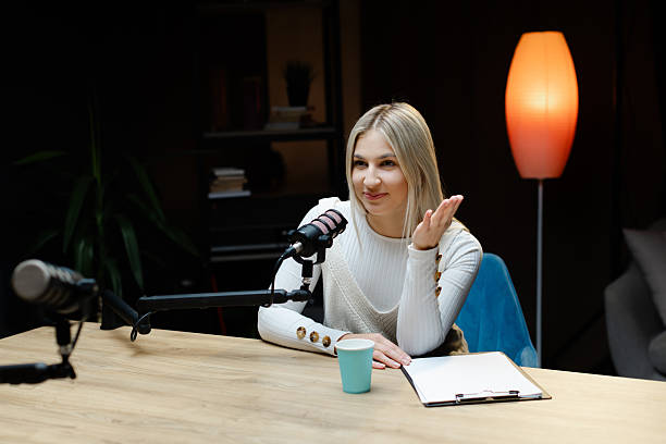 istock Smiling woman recording podcast in home studio 2214264170