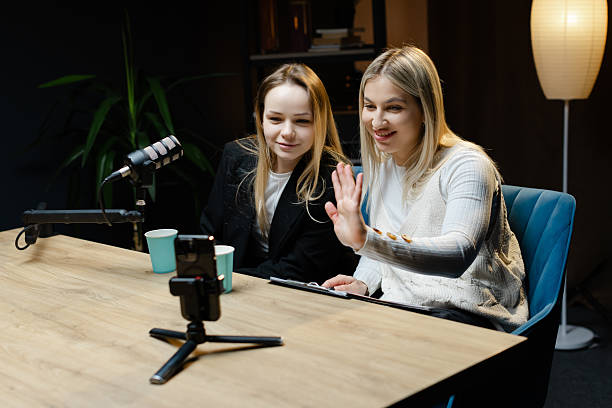 istock Two Content Creators Waving at Camera During Live Podcast Recording 2214264182