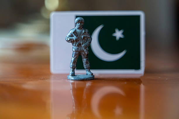 A tin soldier on the background of the flag of Pakistan. India Pakistan military conflict