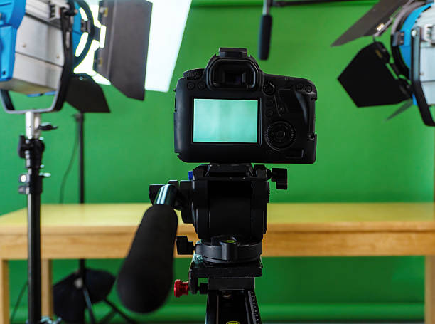 istock Professional video camera recording with green screen background and studio lights 2214267240