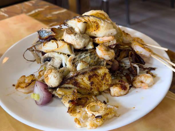 istock Grilled seafood platter with fish, shrimp, and octopus on a white plate 2214272453