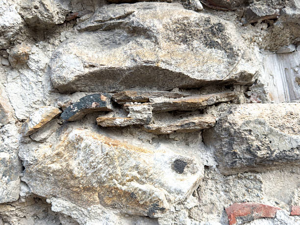 istock Close-up of ancient stone wall with weathered rocks and cracks 2214272580