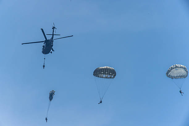 istock Army Paratroopers exit a helicopter in mid-air during a training exercise, highlighting their tactical airborne maneuvers. 2214273693