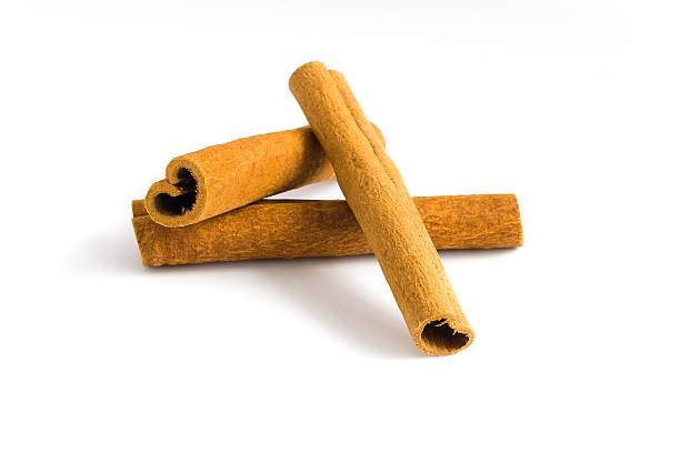 istock Cinnamon bark pieces laid out on white, emphasizing their textured surfaces and warm earthy tones. 2214277992