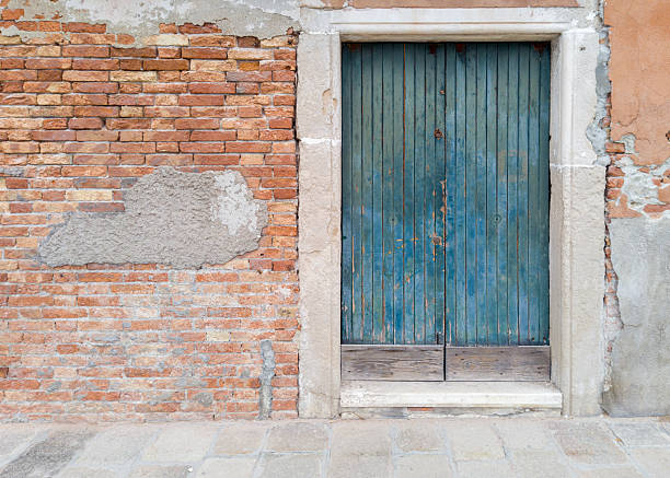 Old blue wooden door in brick wall