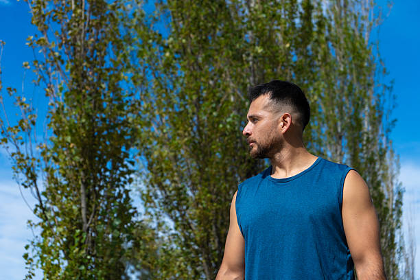 Sportsman standing outdoors looking away with focus and determination.