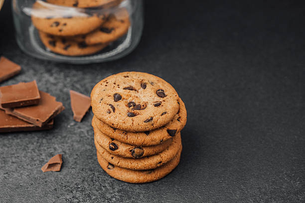 istock Cookies stacked next to chocolate pieces on a dark surface during a cozy moment 2214287662