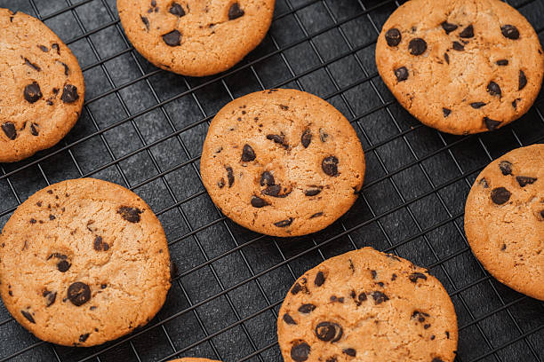 istock Freshly baked chocolate chip cookies cooling on a wire rack in a kitchen 2214287666