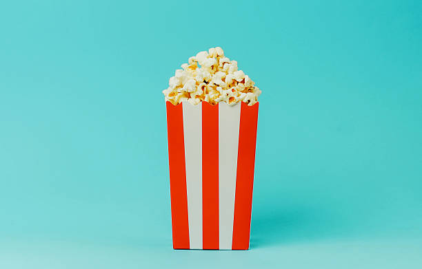 istock Popcorn in a red and white striped container against a blue background 2214287687