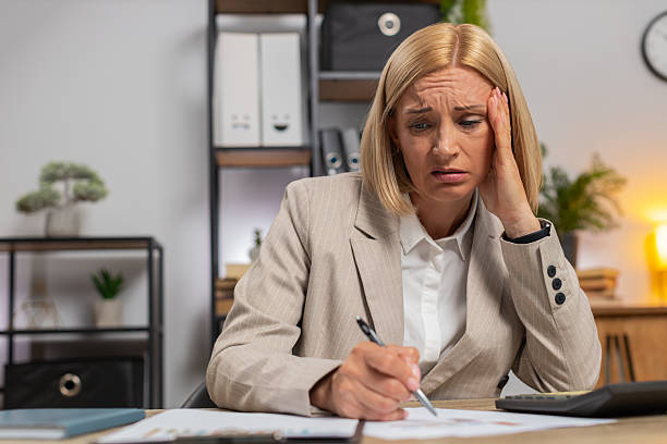 istock Upset mature businesswoman using calculator feeling worried about financial problem at office desk 2214291497