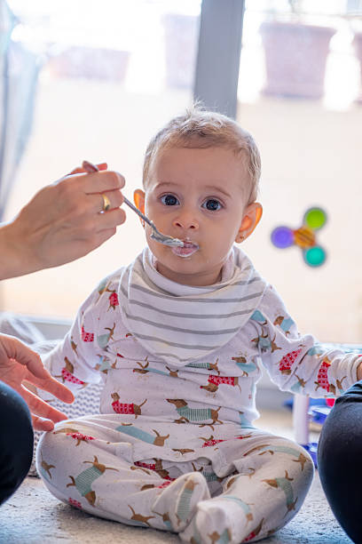 istock Baby Being Fed by Parent in Comfortable Home Setting 2214300909