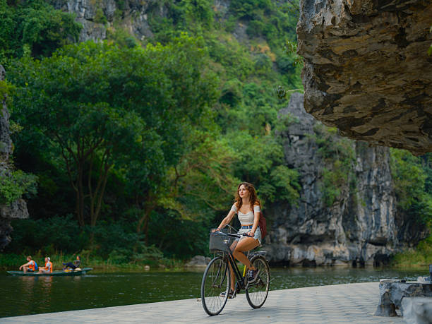 istock Woman exploring Ninh Binh on bicycle 2214302695