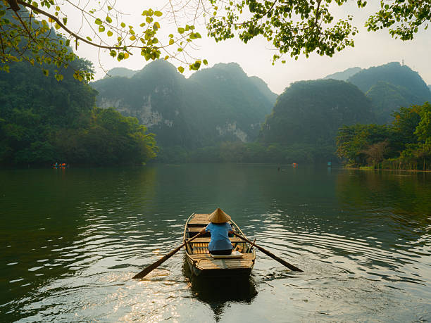 Boat on river surrounded by karst formations in Ninh Binh, Vietnam