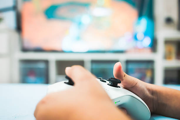 A child with a gamepad is playing in the bed room.