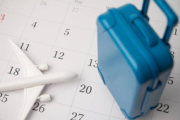 istock Travel suitcase and airplane on blank white calendar background. 2214307219