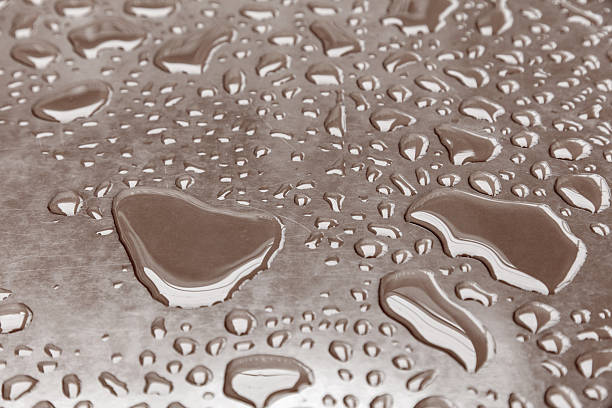 Water drops on morning sun on metallic surface.