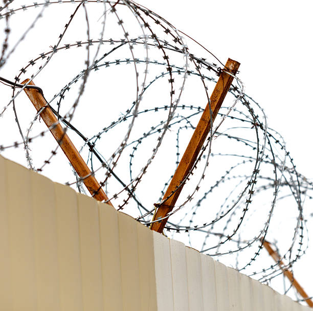 istock A fence with barbed wire on top of it 2214313472