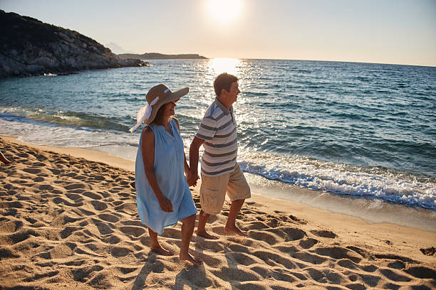 istock Senior couple enjoying walking along the beach 2214315250