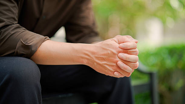 istock Young Asian man feeling stressed in a public park after having a bad day. 2214315536