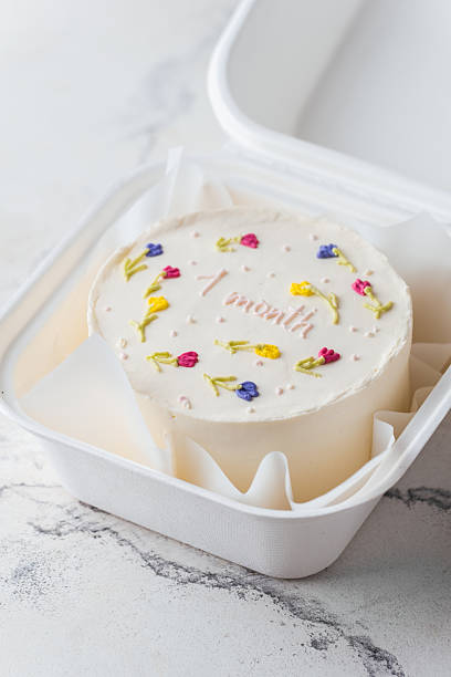 istock small trendy bento anniversary cake with congratulation text one month on top. Birthday cake for a little baby  in a white gift box on the white marble background 2214318891