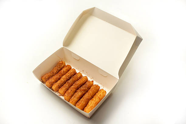 Detail of a man's hand holding a churro. Churros are a traditional breakfast in Spain.