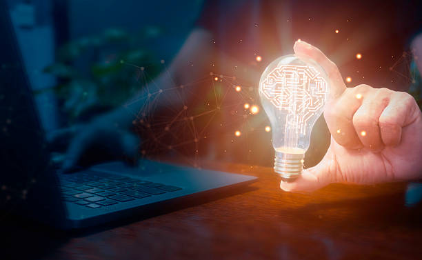 istock Businessman using laptop and holding glowing light bulb with artificial intelligence brain icon and connection line, creative thinking ideas and innovation concept. 2214324684