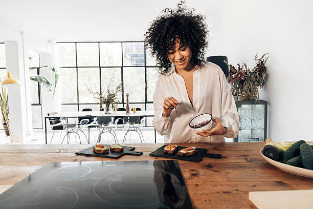 istock Young chef adding spices to avocado toast in modern kitchen 2214332163