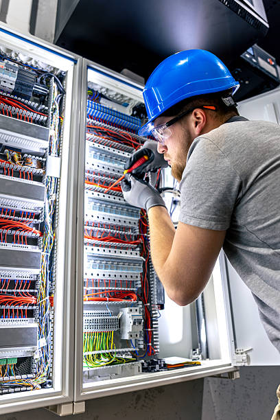 istock Male electrician in uniform working in a switchboard. Electricity. 2214338916