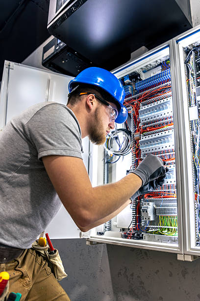 istock Male electrician in uniform working in a switchboard. Electricity. 2214338920