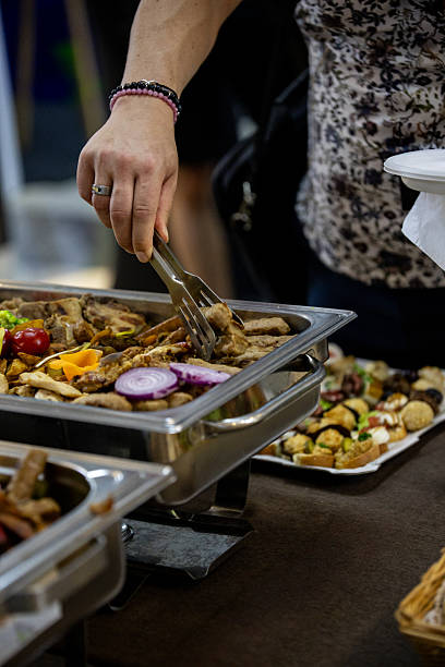 istock Diverse buffet showcase with a hand serving food at a catered event 2214340268