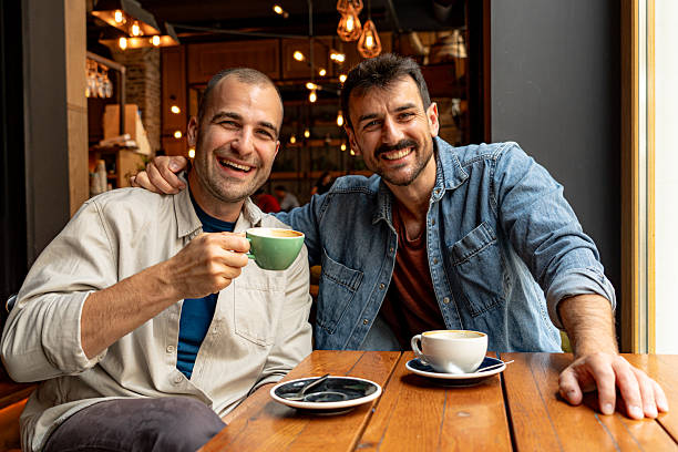istock Two cheerful men enjoying coffee break together in cafe 2214341092