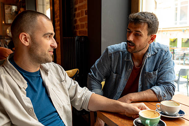 istock Two men talking and drinking coffee in a cafe 2214341885