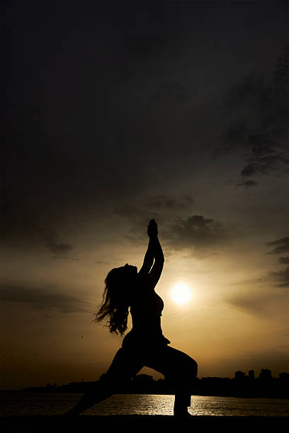 A man traveling alone stands with his back to us and looks forward into the sky.