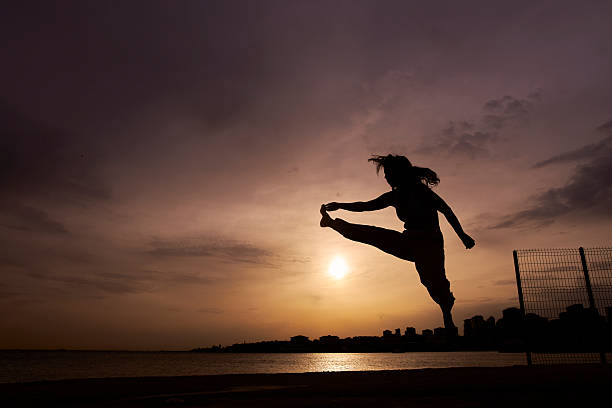 silhouette of a woman at sunset yoga cloudy sky