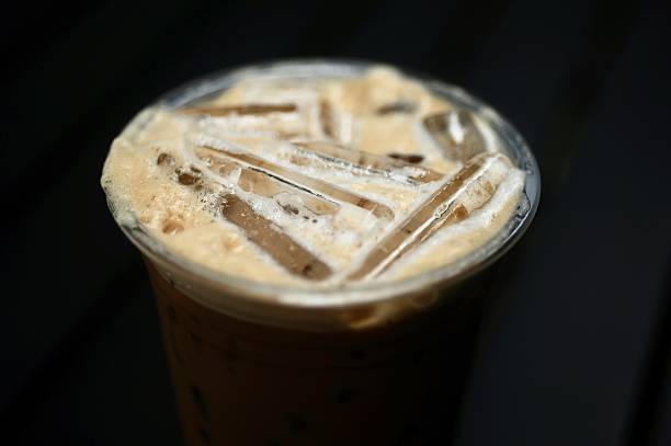 istock Iced espresso served in a takeaway cup with lid and straw, placed on a neutral background 2214345943
