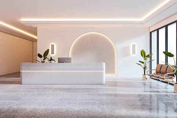 istock Modern reception area with sleek marble desk, warm backlit arch, indoor plants, and ceiling lights in office interior setting. 3D Rendering 2214346102